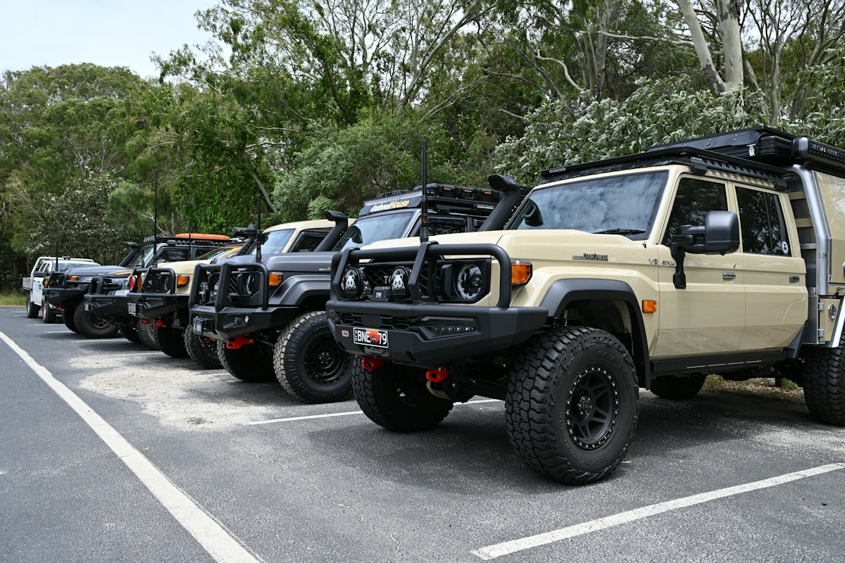 Several off-road vehicles parked in a row outdoors