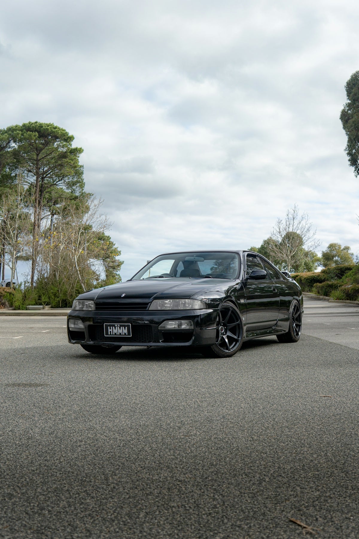 A black sports car parked on an asphalt road