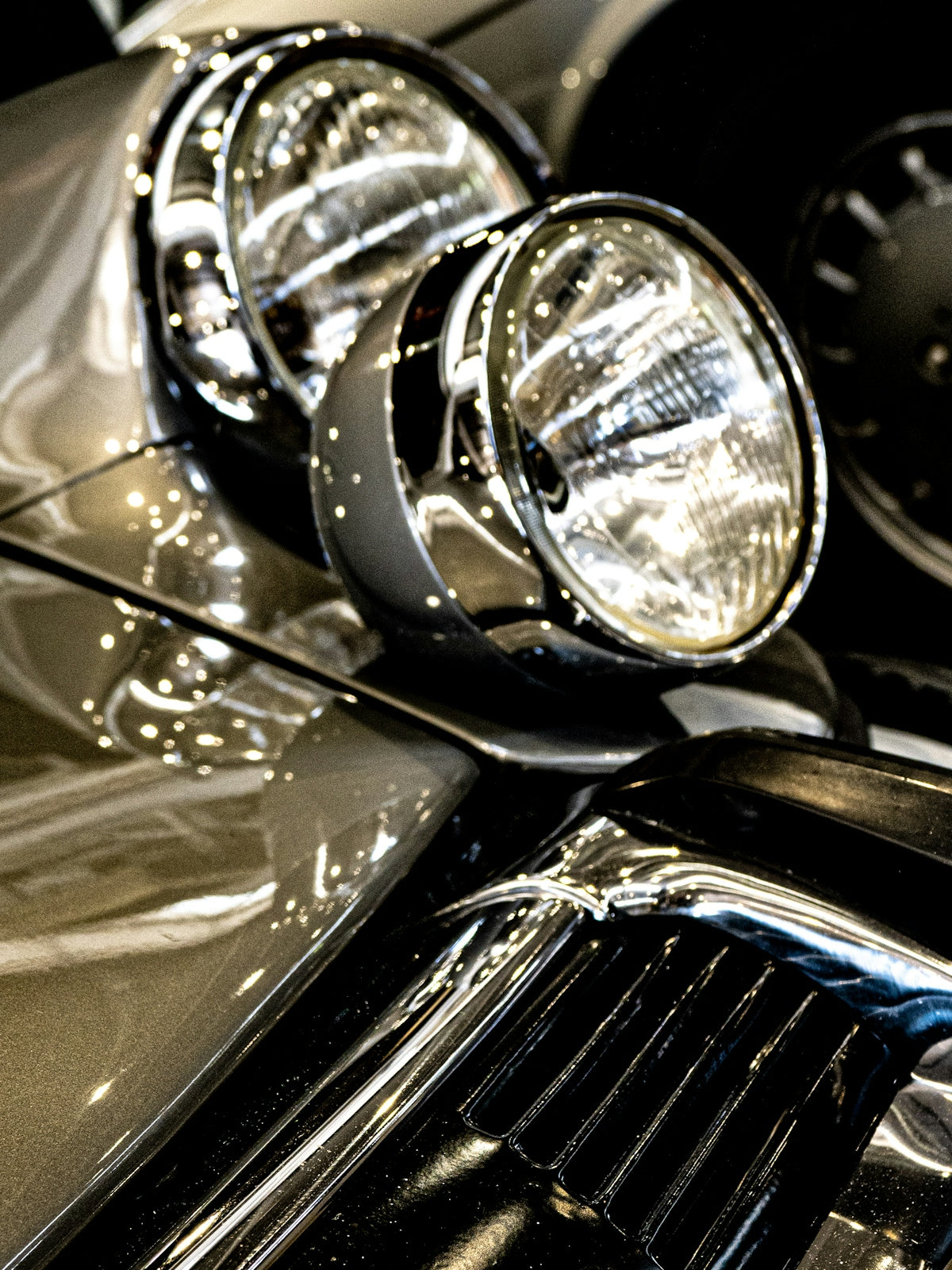 Shiny car headlights and chrome details are shown.