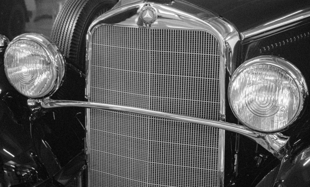 Close-up of a vintage car's grille and headlights