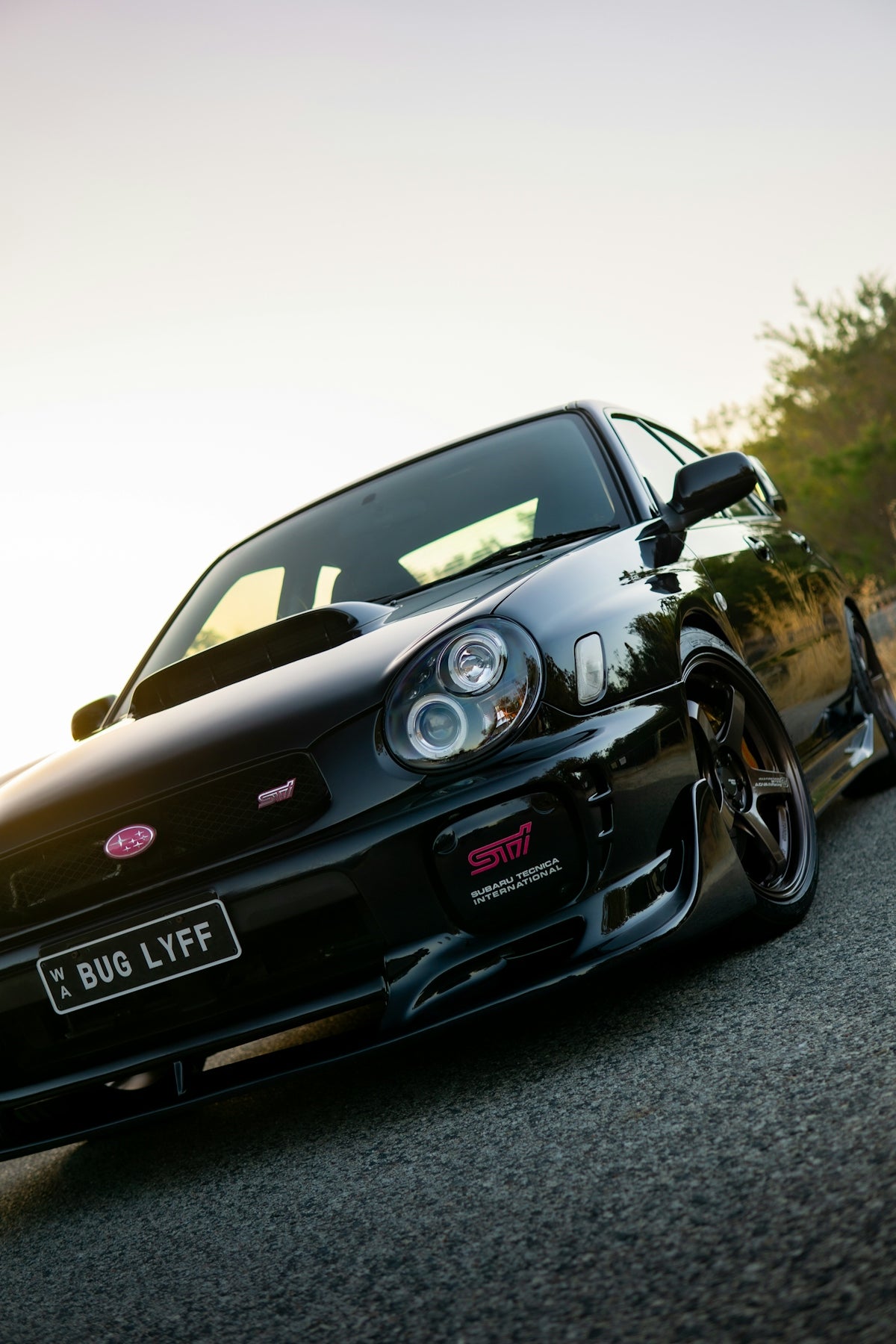 A black subaru wrx sti parked on a street.